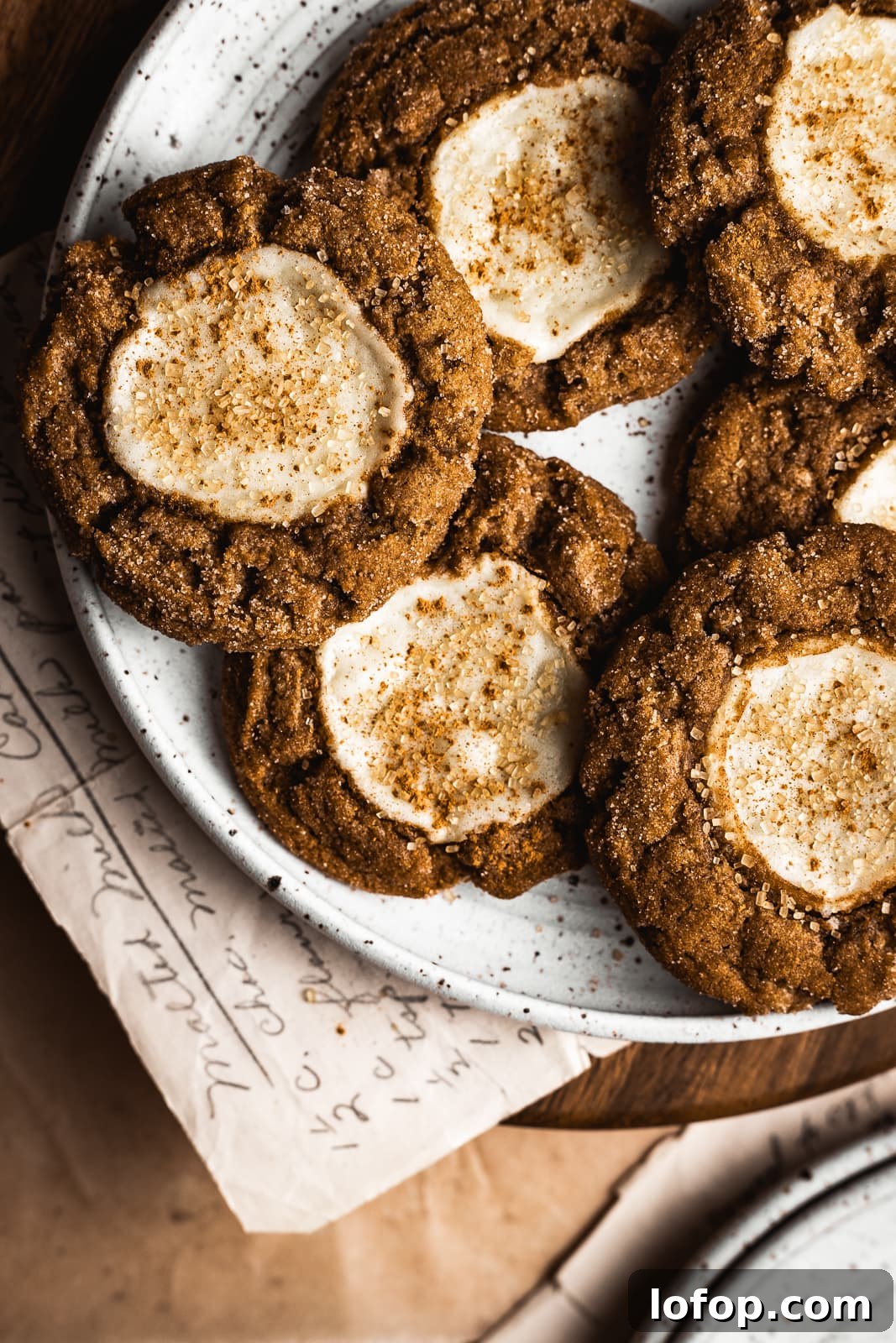 Pumpkin cookies with a cream cheese center on a white plate.