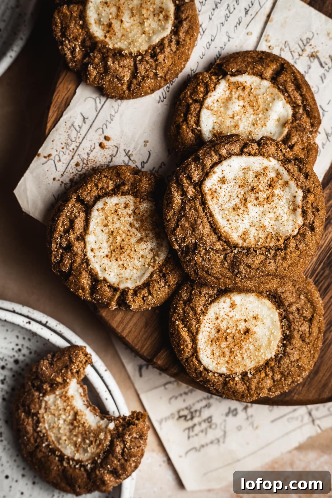 Pumpkin cookies on a wooden board with recipe and partially eaten cookie nearby
