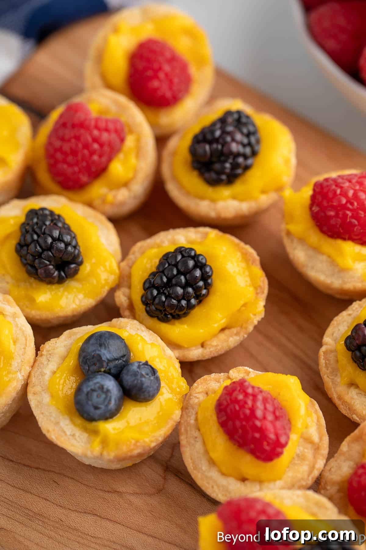 Mini Lemon Tarts Recipe: Zesty Bite-Sized Citrus Pastries 9 Mini Lemon Tartlets topped with berries.