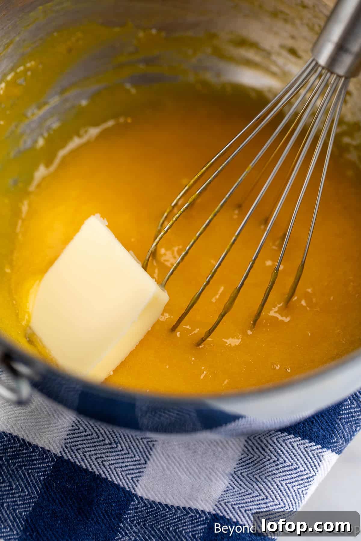 Mini Lemon Tarts Recipe: Zesty Bite-Sized Citrus Pastries 5 Whisking butter into lemon curd.