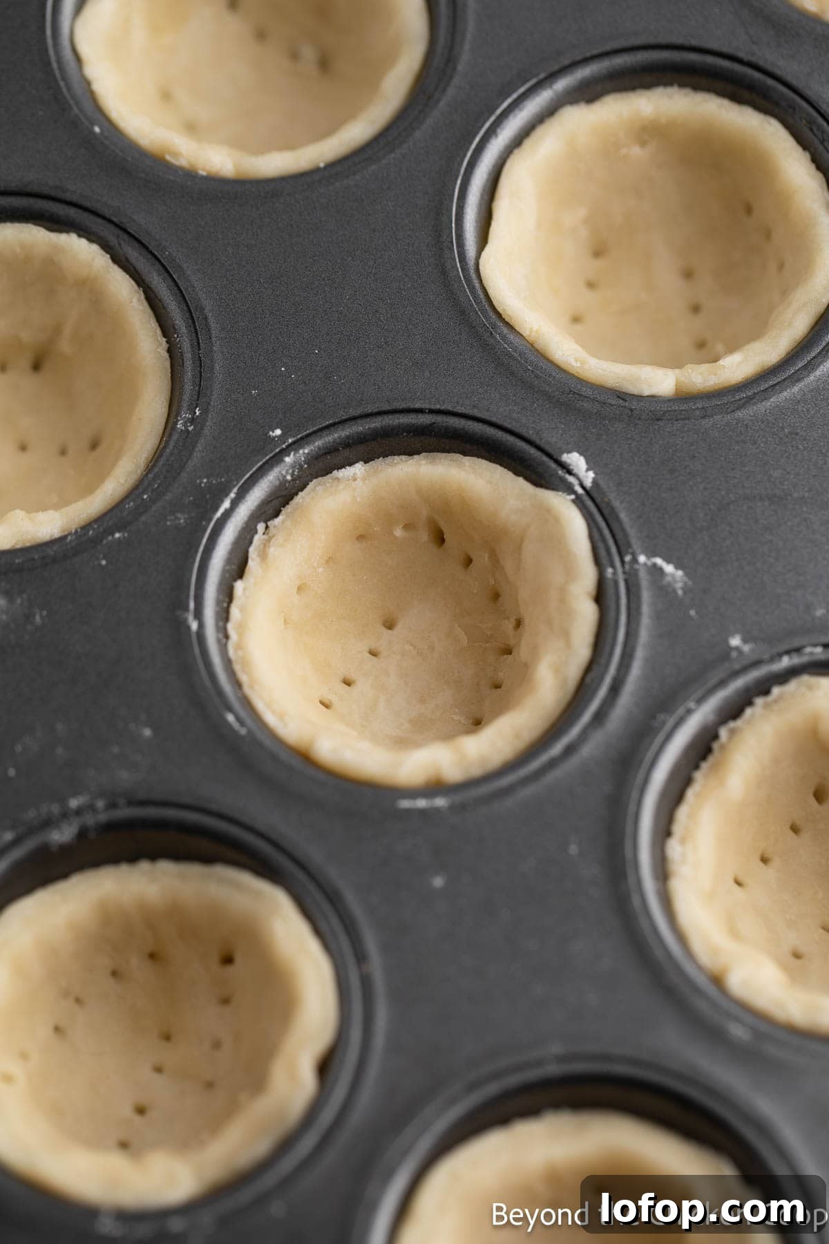 Mini Lemon Tarts Recipe: Zesty Bite-Sized Citrus Pastries 6 Mini pie crust with small holes in the crust.