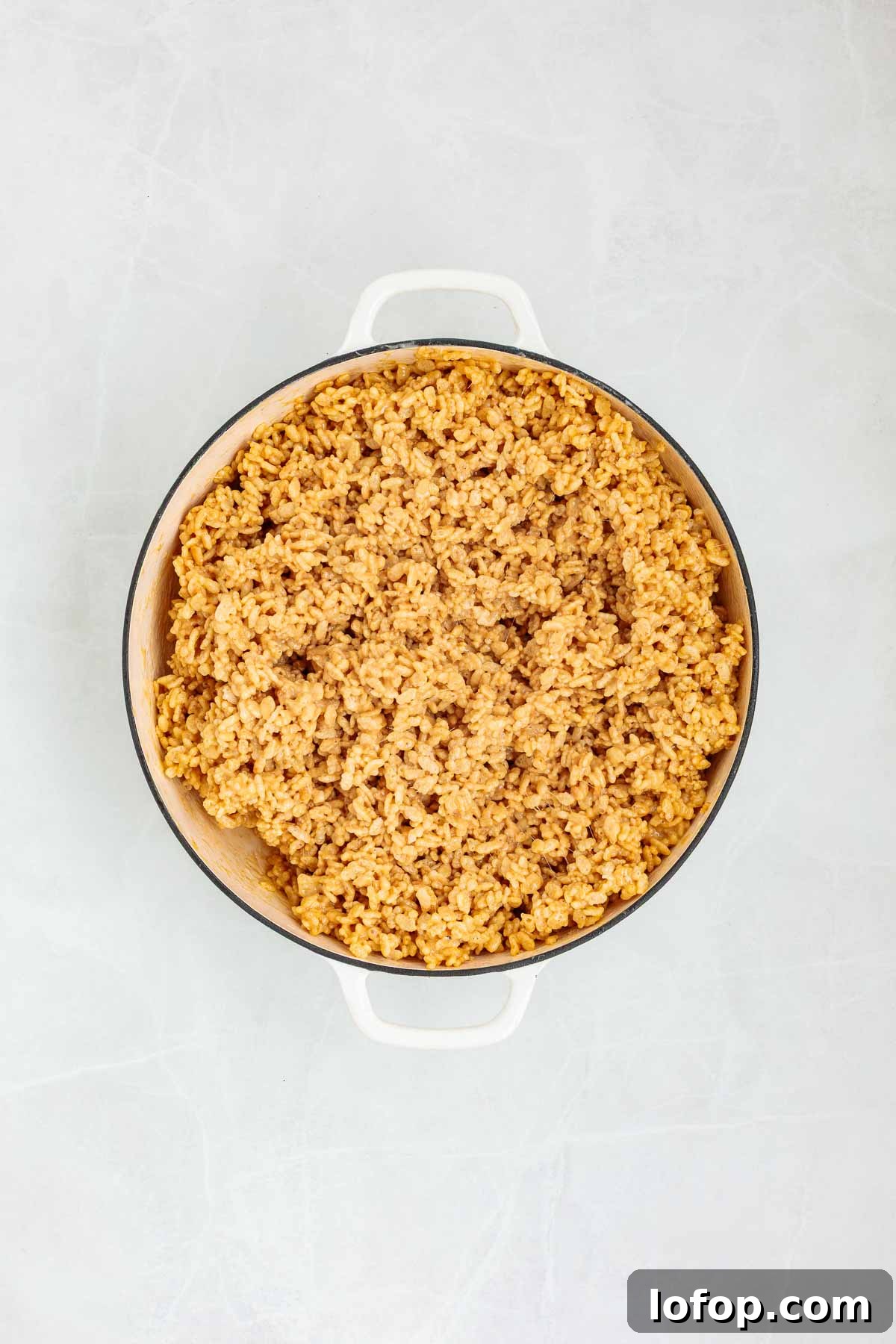 Chocolate Peanut Butter Rice Krispie Treat Recipe 6 Crispy rice cereal fully mixed into the melted peanut butter-marshmallow base, forming a thick and sticky mixture in a large pot.