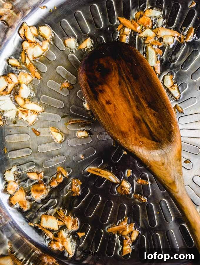 Sauteing garlic in pan with olive oil.