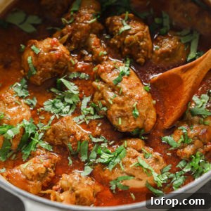 Authentic Chicken Curry in a dutch oven garnished with cilantro