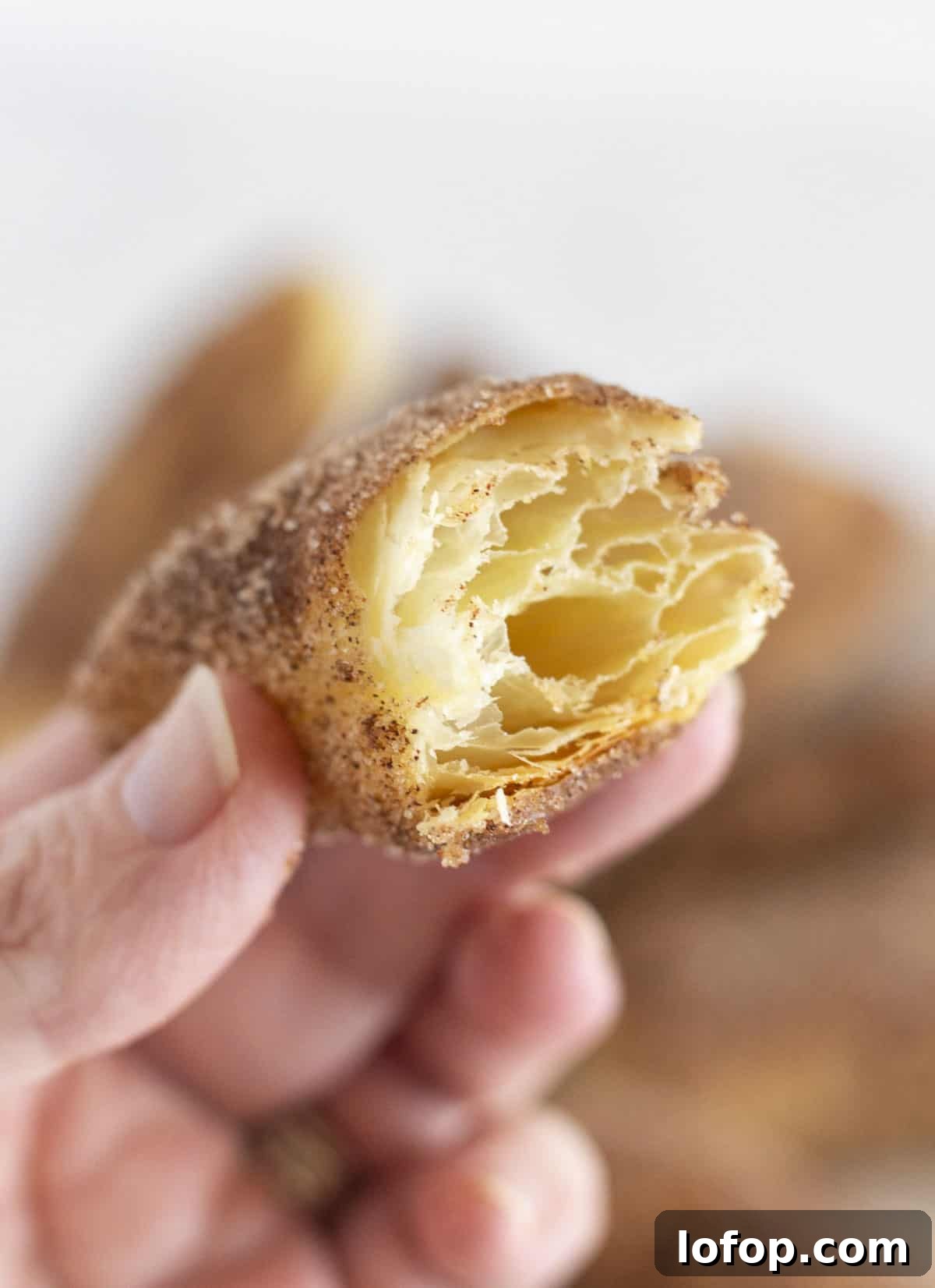 Showing the inside of a baked churro with the pastry layers.