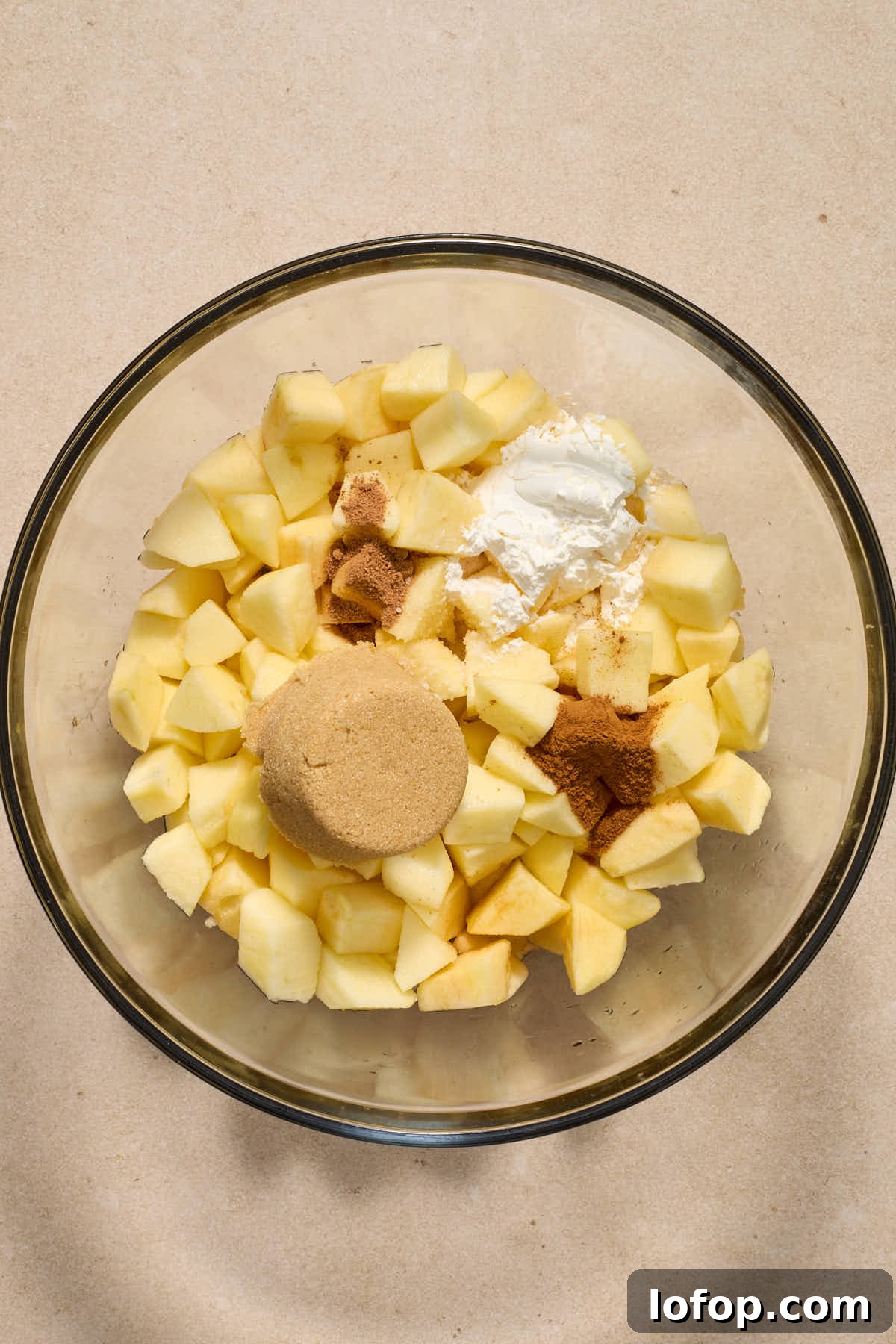 Chopped apples and other filling ingredients in a large glass bowl.