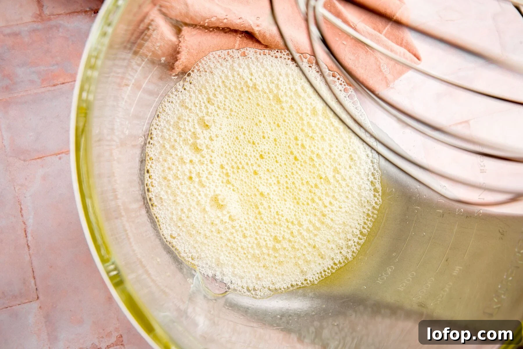 Egg whites frothed slightly in a mixing bowl.