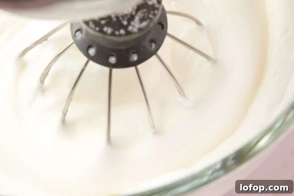 Stand mixer whipping egg whites and sugar.