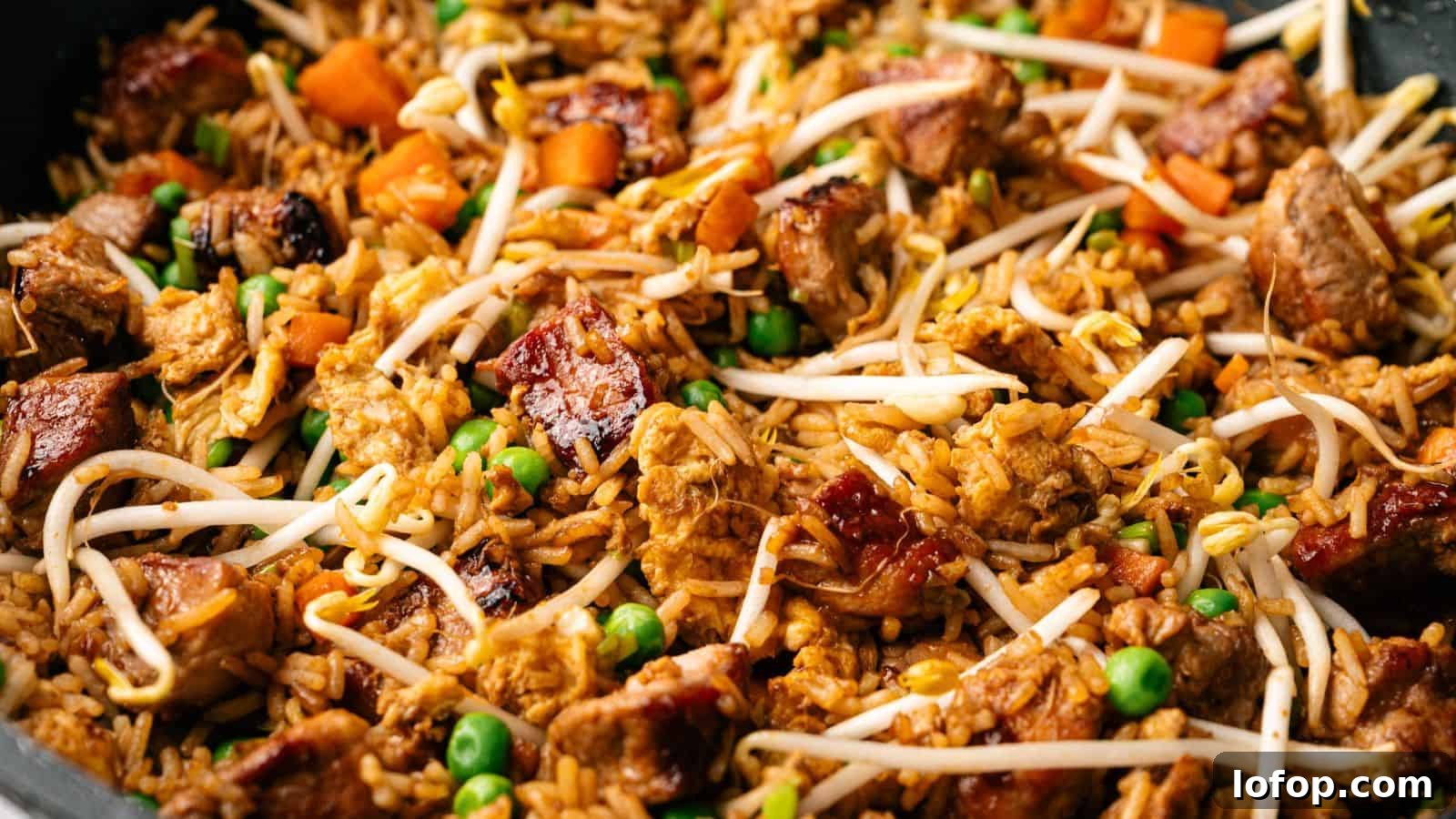 31 Budget-Friendly Winter Meals to Stretch One Grocery Trip Into a Week 3 Close-up of fried rice with chunks of meat, peas, diced carrots, and bean sprouts mixed together.