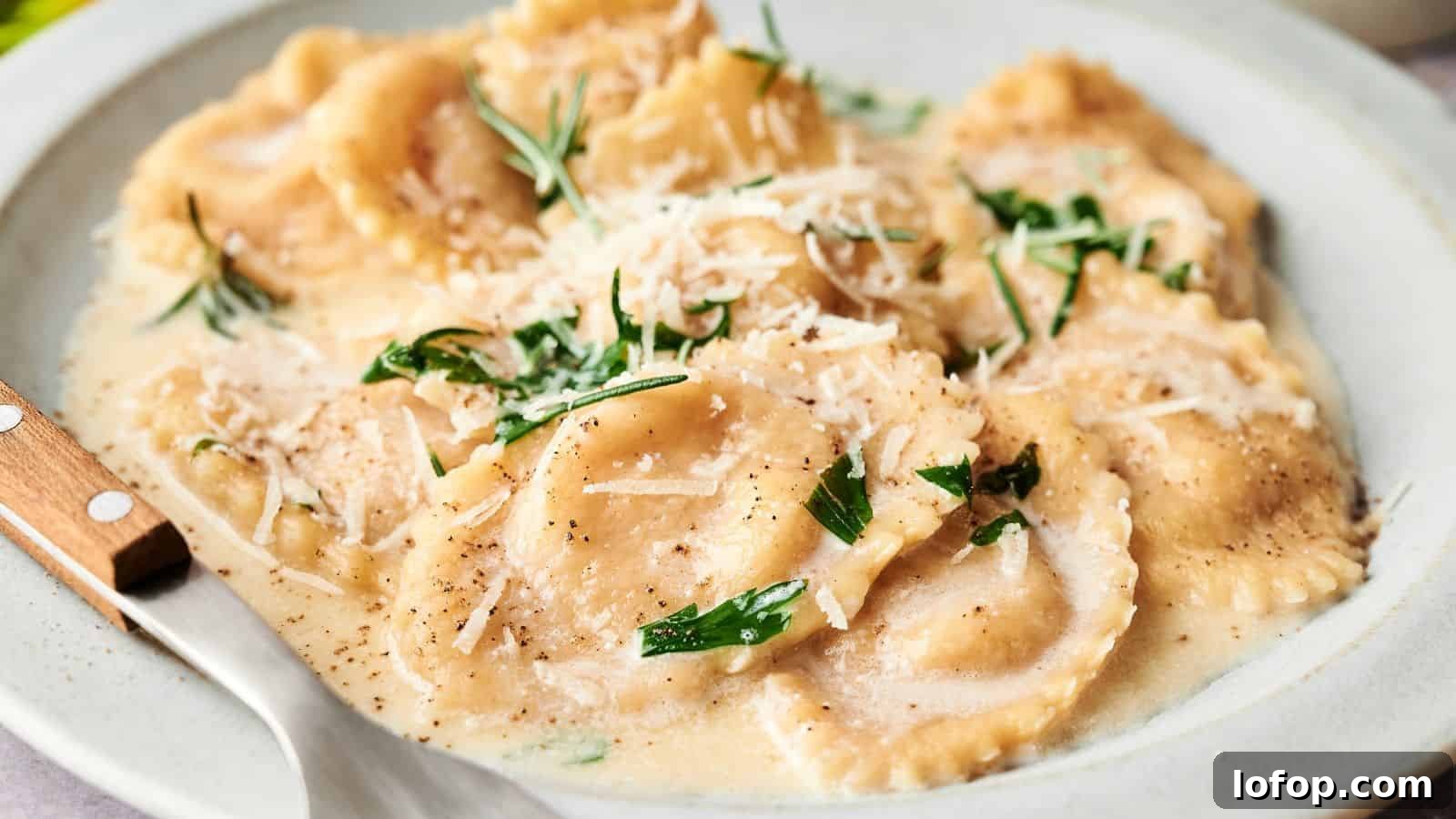 31 Budget-Friendly Winter Meals to Stretch One Grocery Trip Into a Week 23 A plate of ravioli topped with creamy sauce, grated cheese, and fresh herbs, served with a fork.