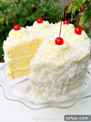 Sliced Pina Colada Cake on a glass pedestal.