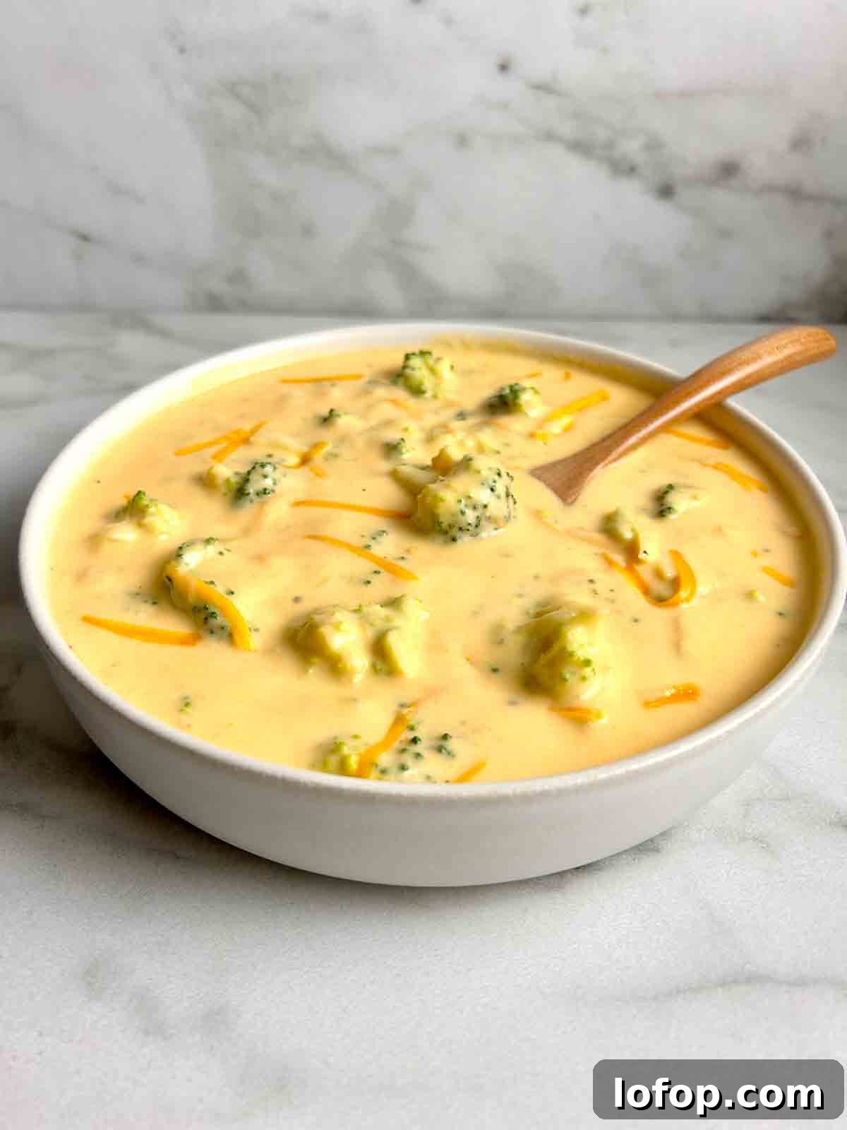side view of broccoli cheddar soup in bowl.