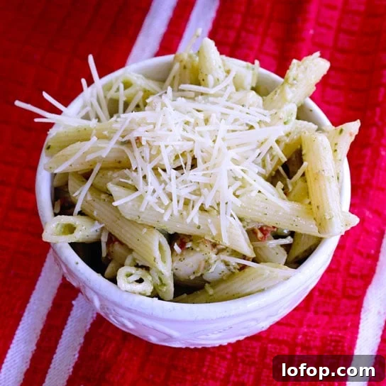 Creamy Pesto Pasta Salad Made with Store-Bought Pesto 9 creamy pesto pasta salad in a white bowl on a red kitchen towel
