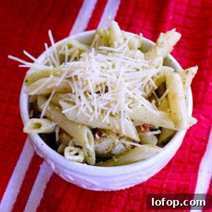 Creamy Pesto Pasta Salad Made with Store-Bought Pesto 10 creamy pesto pasta salad in a white bowl on a red kitchen towel