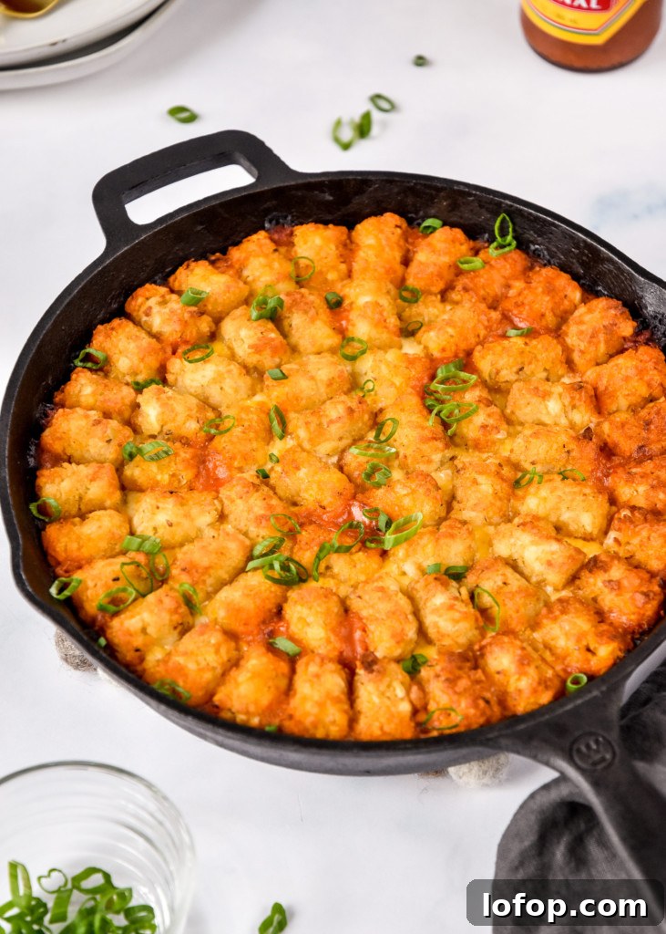 cooked and garnished turkey sloppy joe tater tot casserole in a cast iron.