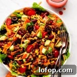 Crispy Dorito Taco Salad Recipe for Game Day and Weeknight Meals 11 Taco Salad dizzled with Catalina dressing and a jar of it to the side.
