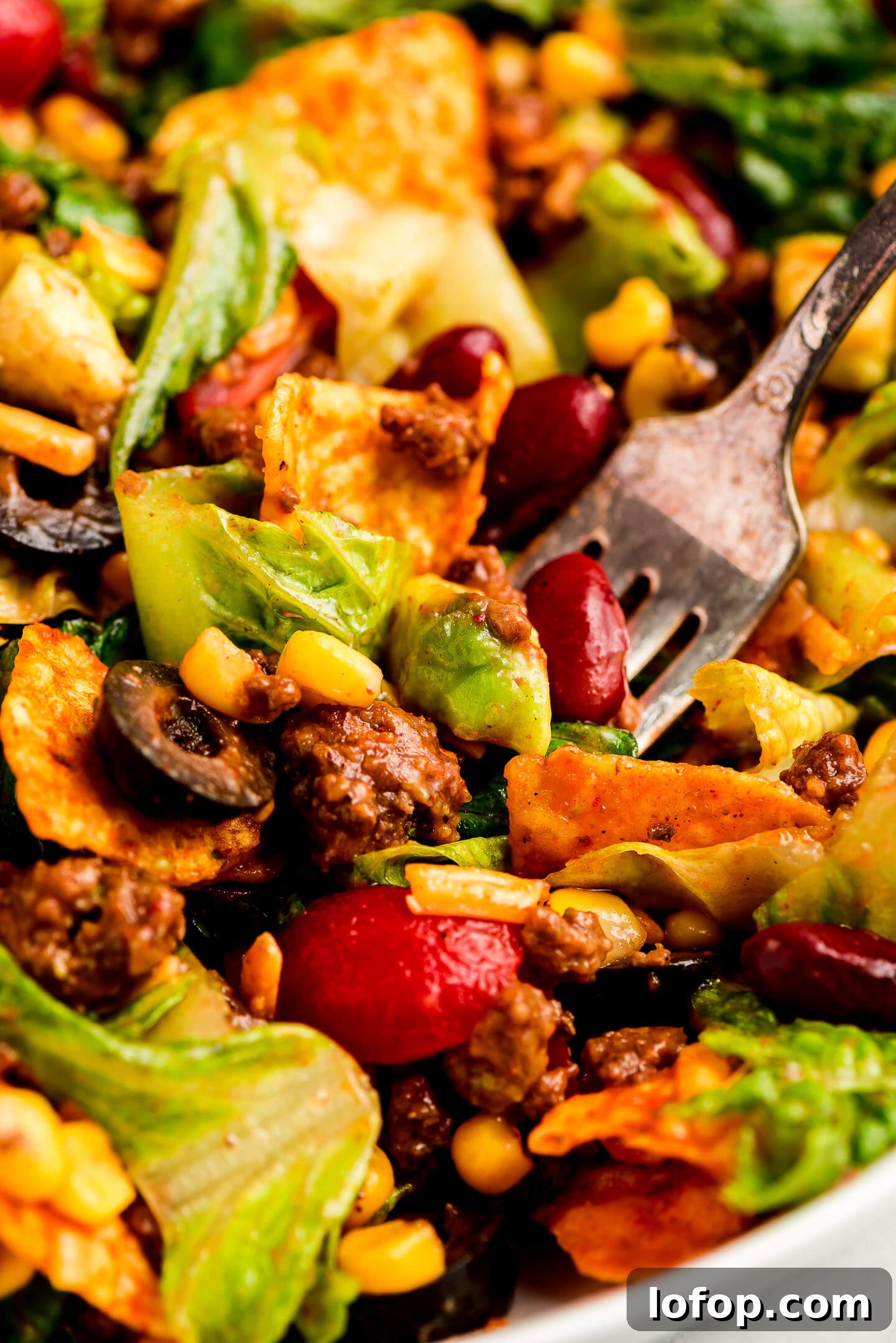 Crispy Dorito Taco Salad Recipe for Game Day and Weeknight Meals 4 Close up shot of a fork full of Taco Salad.