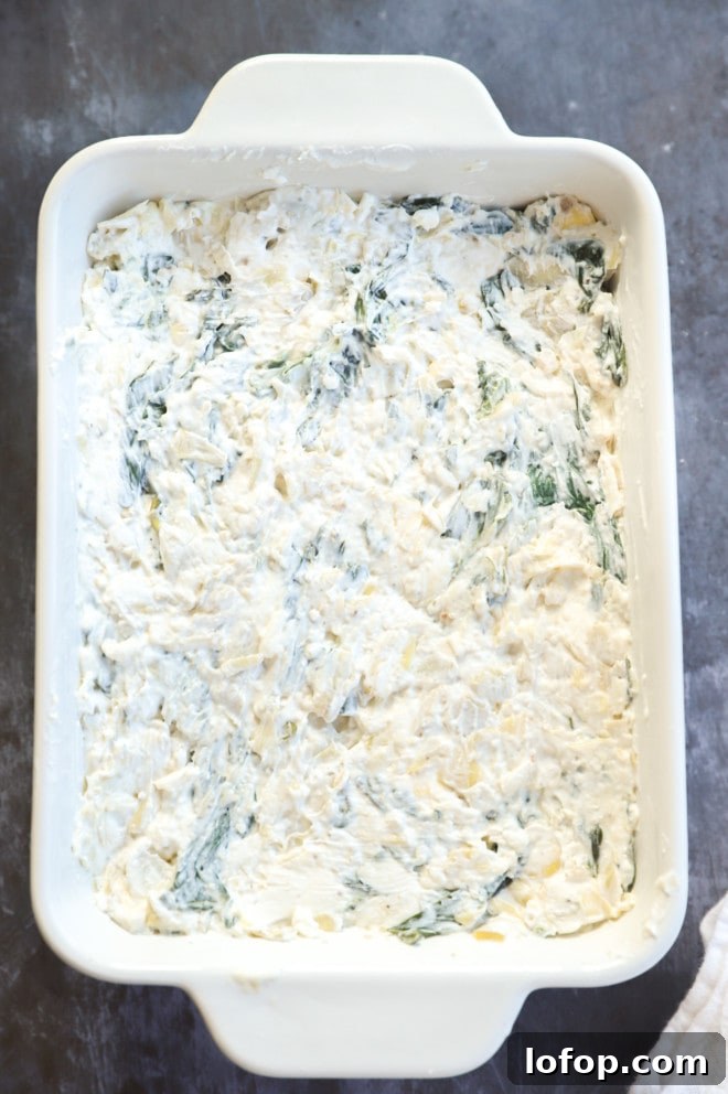 spinach artichoke cheese dip before baking in casserole dish