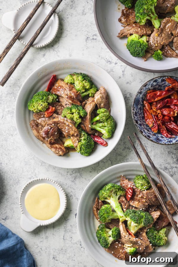 Keto-Style Beef and Broccoli Stir-Fry Recipe 2 Keto beef and broccoli with dried red peppers in bowls with chopsticks and Chinese mustard.