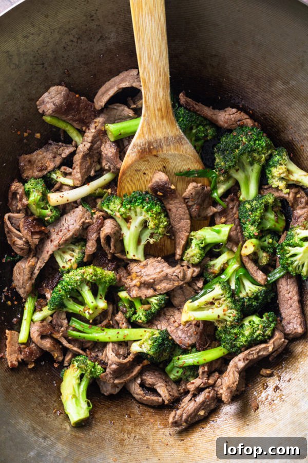 Keto-Style Beef and Broccoli Stir-Fry Recipe 3 Keto beef and broccoli stir fry in a wok with bamboo spoon