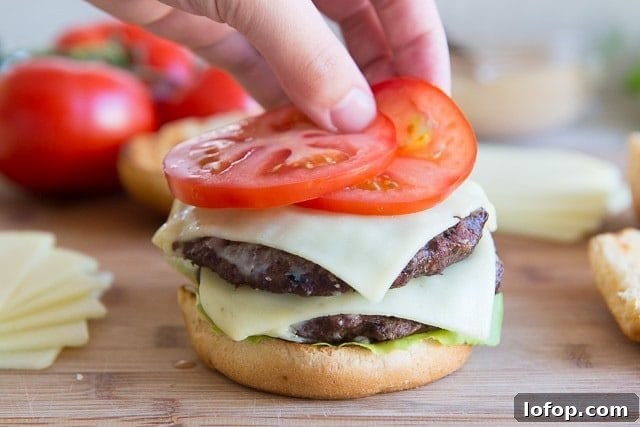 Double Decker Burger Recipe: How to Build a Juicy Stacked Burger 10 Adding Fresh Tomato Slices to Bun with Two Beef Patties and Cheese Slices