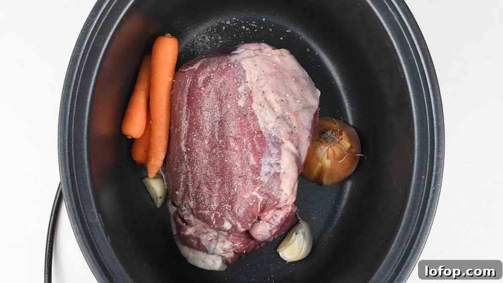 Slow Cooker Leg of Lamb with Garlic and Herbs 5 Half leg of lamb in a slow cooker with carrots, onion and garlic