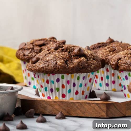 Several gluten free chocolate muffins sitting on a wood tray.