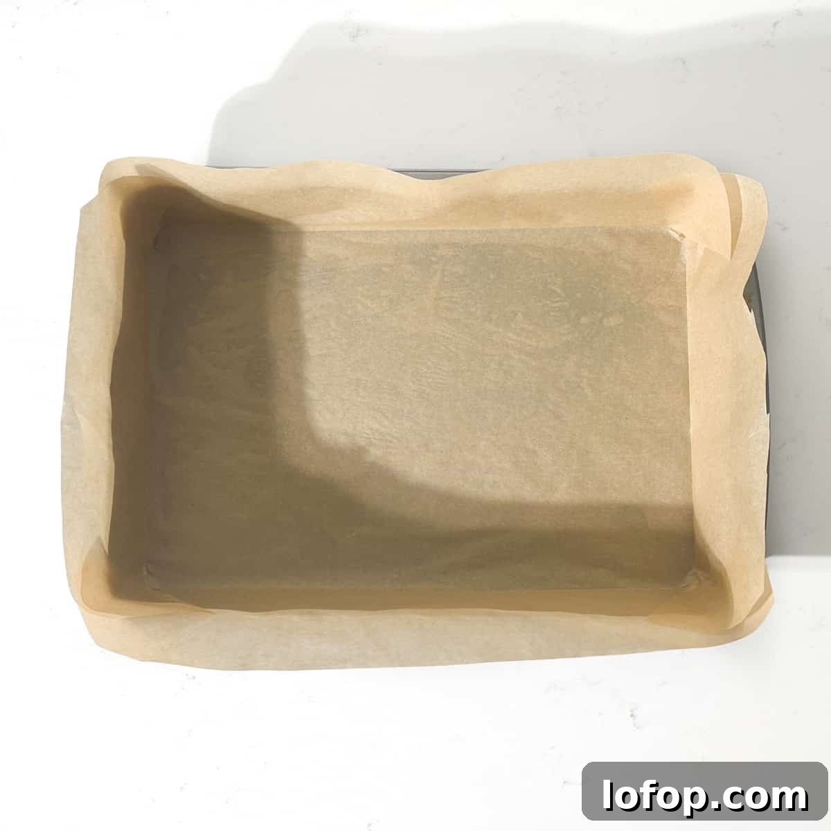 A baking tin neatly lined with baking paper.