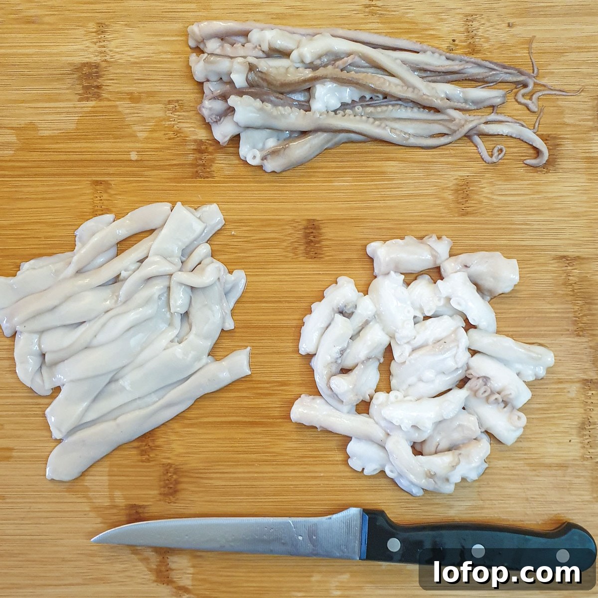 Pieces of octopus on a chopping board.