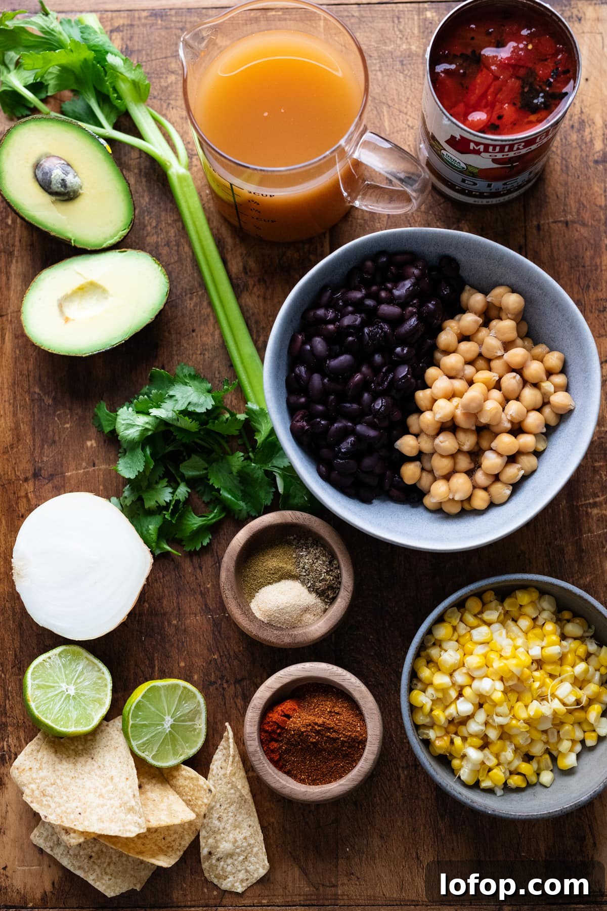 Hearty Vegetarian Black Bean Tortilla Soup Recipe 3 Ingredients for vegetarian tortilla soup arranged on a wooden background.