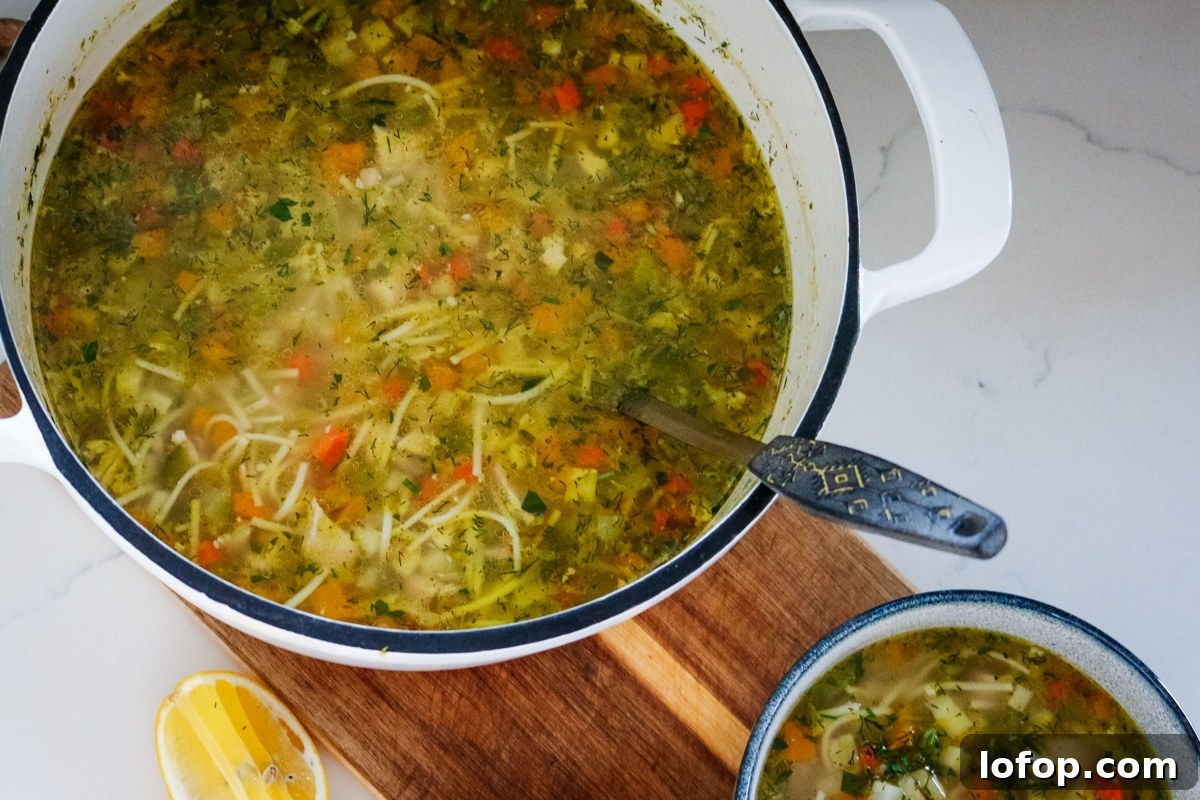 Romanian ciorbă soup served in a white pot and a white bowl.