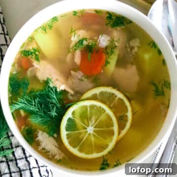 fish soup in white bowl next to spoon