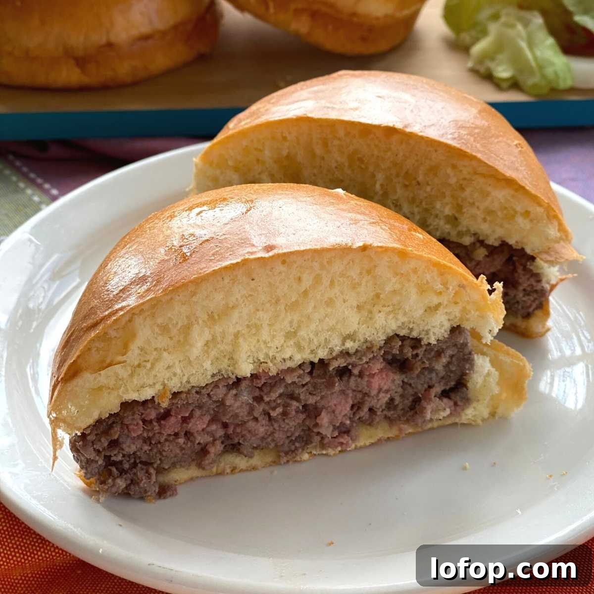 Cooked American Wagyu Beef Burger on bun cut in half.
