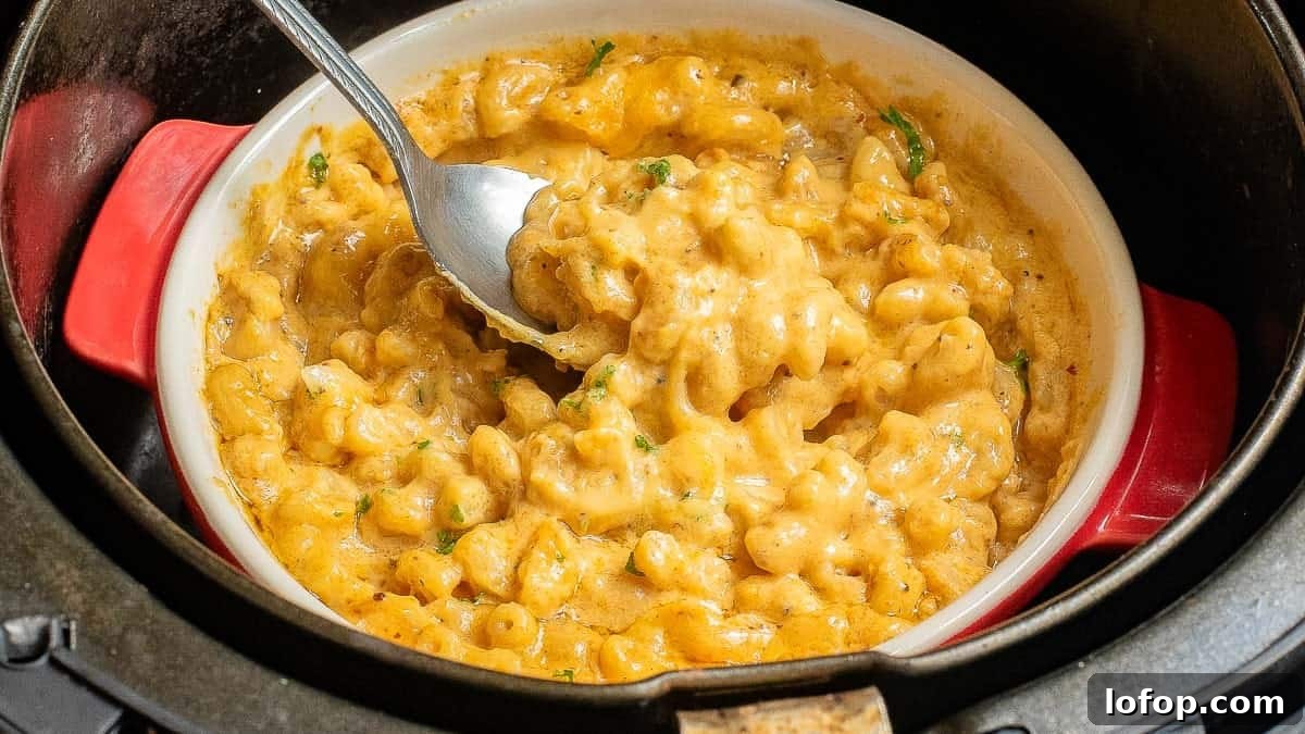 12 Flavor-Packed Meatless Dinners You’ll Love Tonight 14 A bowl of creamy macaroni and cheese with a spoon, inside an air fryer.