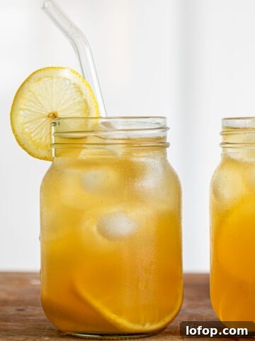 Two glasses of Earl Grey Lemonade, with lemon slice and glass straw.