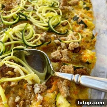 Zucchini and Herb Stuffing Casserole Recipe 13 Baking dish with zucchini casserole and a serving spoon.