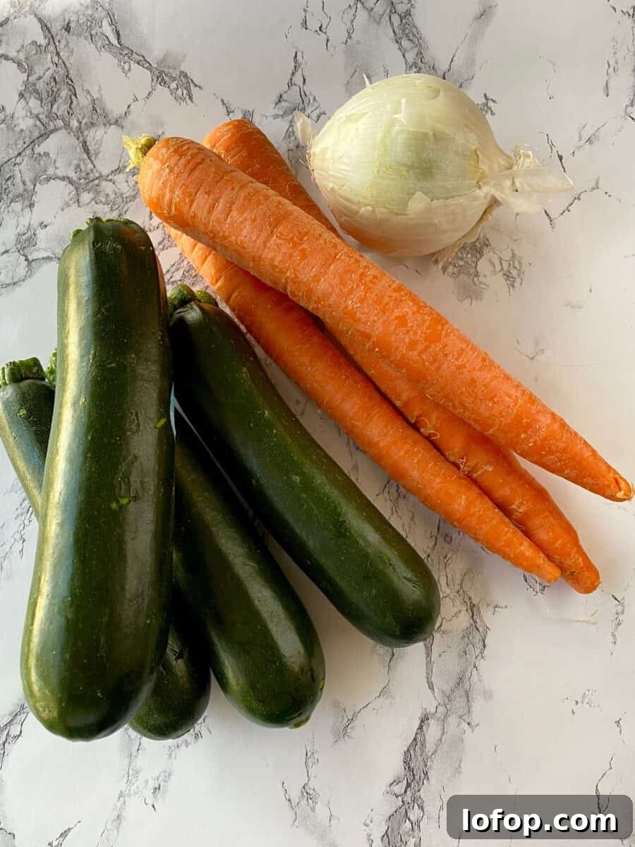 Zucchini and Herb Stuffing Casserole Recipe 3 Four zucchinis, three carrots and an onion on a counter.