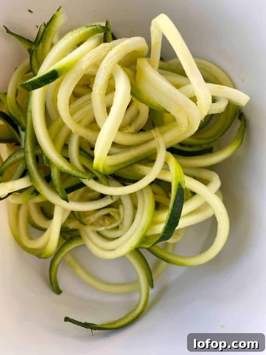 Zucchini and Herb Stuffing Casserole Recipe 6 Curled zucchini noodles in a bowl.