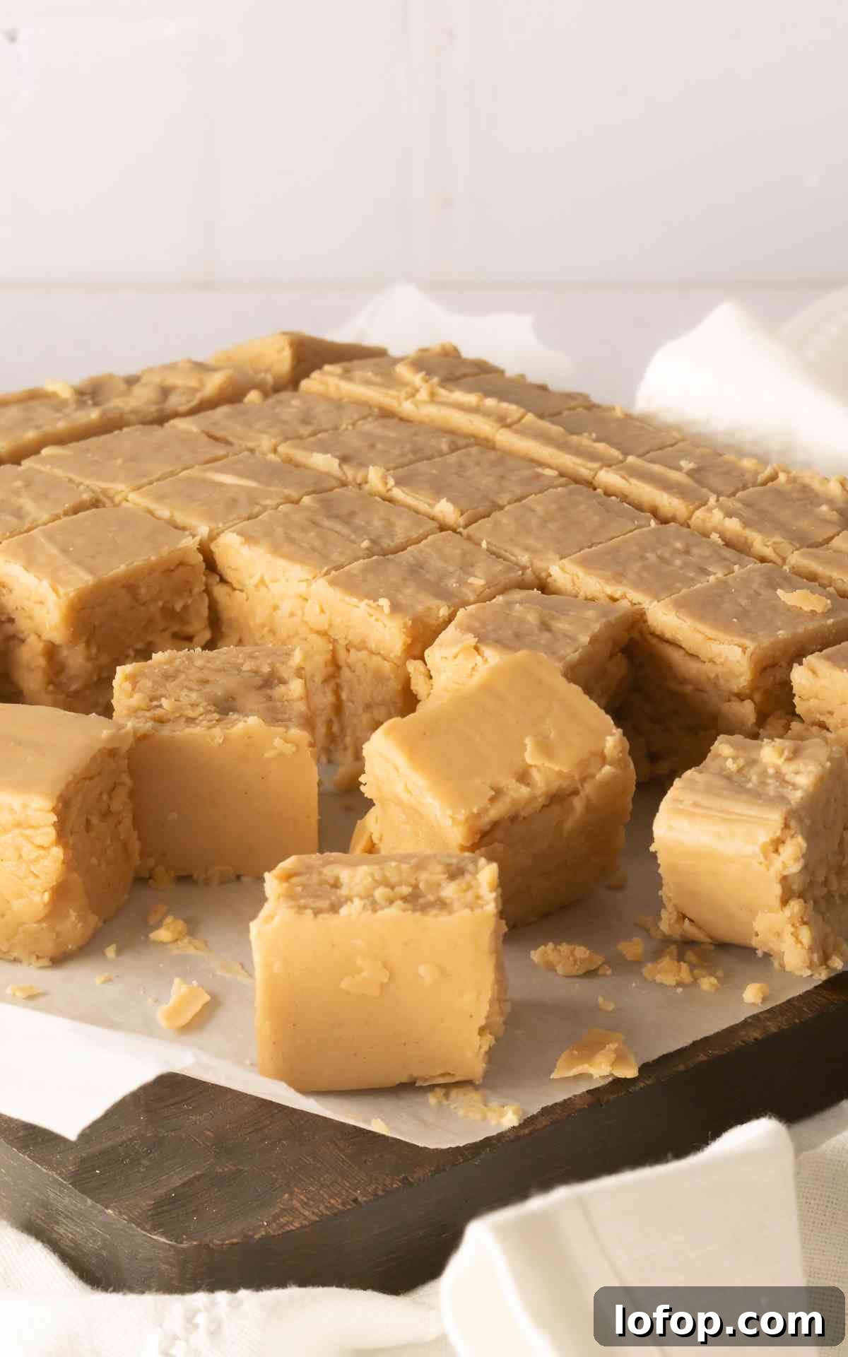Creamy Peanut Butter Fudge Recipe for Rich Homemade Candy 5 Close up of squares of peanut butter fudge on cutting board.