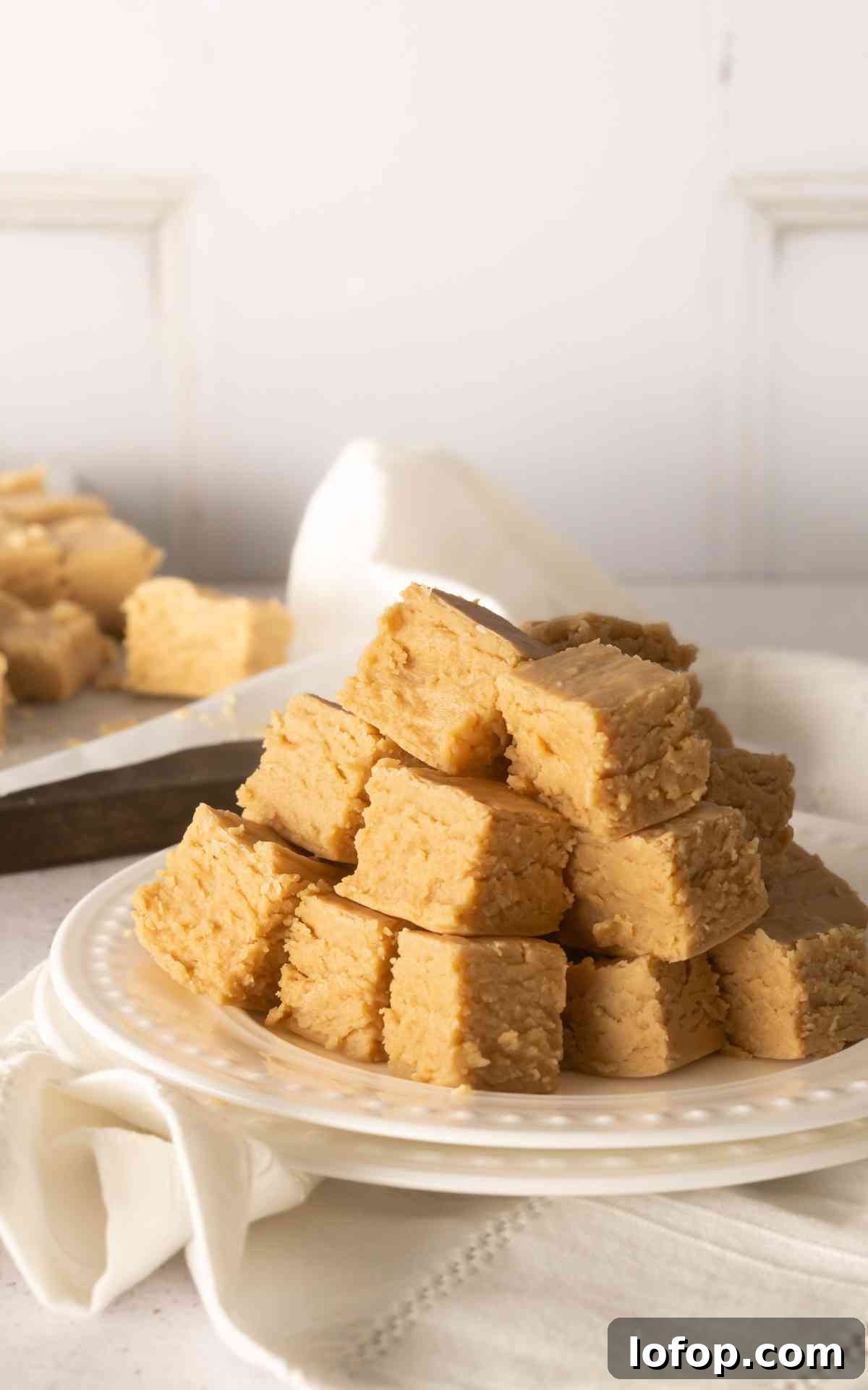 Creamy Peanut Butter Fudge Recipe for Rich Homemade Candy 7 A plate stacked high with creamy peanut butter fudge.