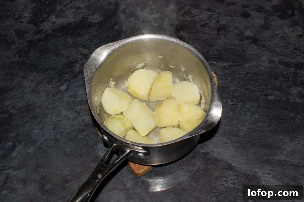 par boiled potatoes fluffed up in a pan