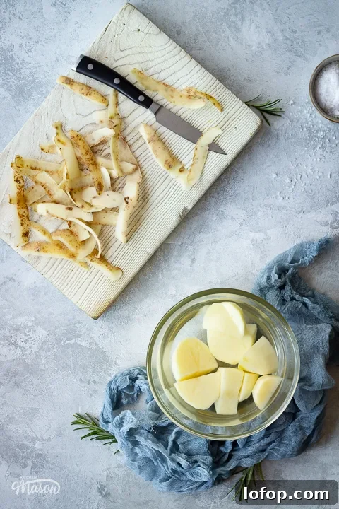 Potato peelings on a board and a bowl of peeled potatoes