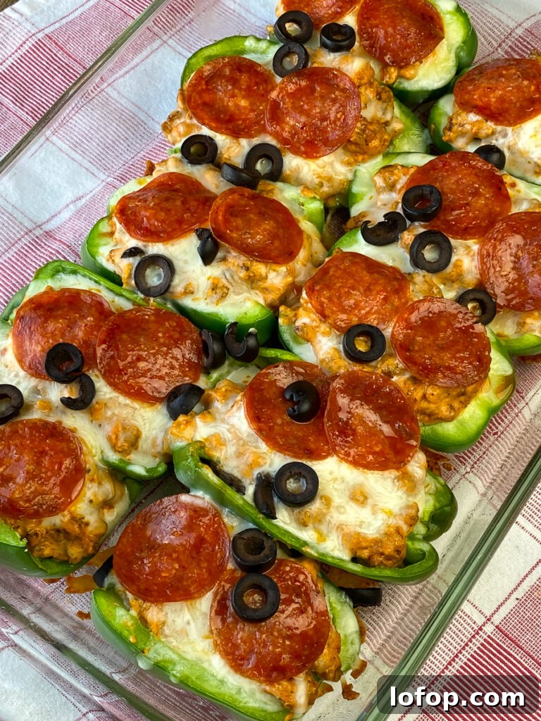 Creamy Pizza-Stuffed Bell Peppers Recipe for Weeknight Dinner 4 9 x 13 pan of easy pizza stuffed bell peppers on a red and white plaid napkin