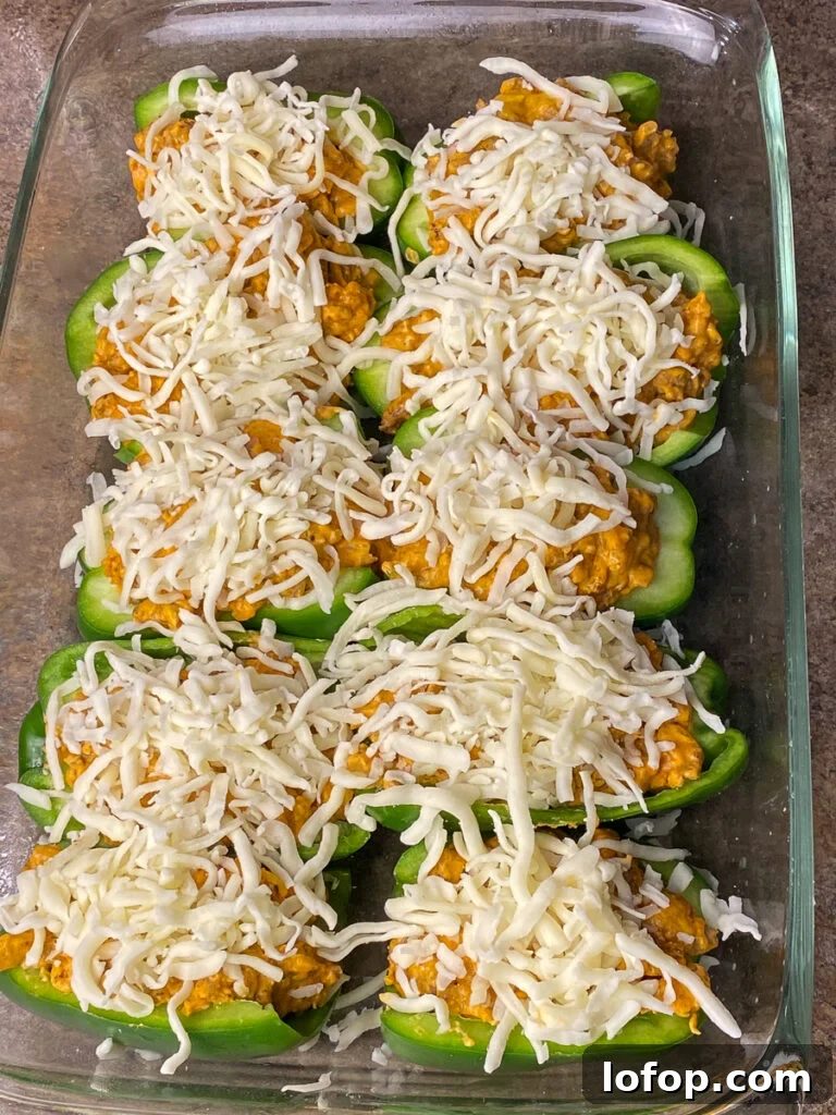 Creamy Pizza-Stuffed Bell Peppers Recipe for Weeknight Dinner 9 Shredded mozzarella cheese on top of pizza stuffed green peppers in a 9 x 13 pan