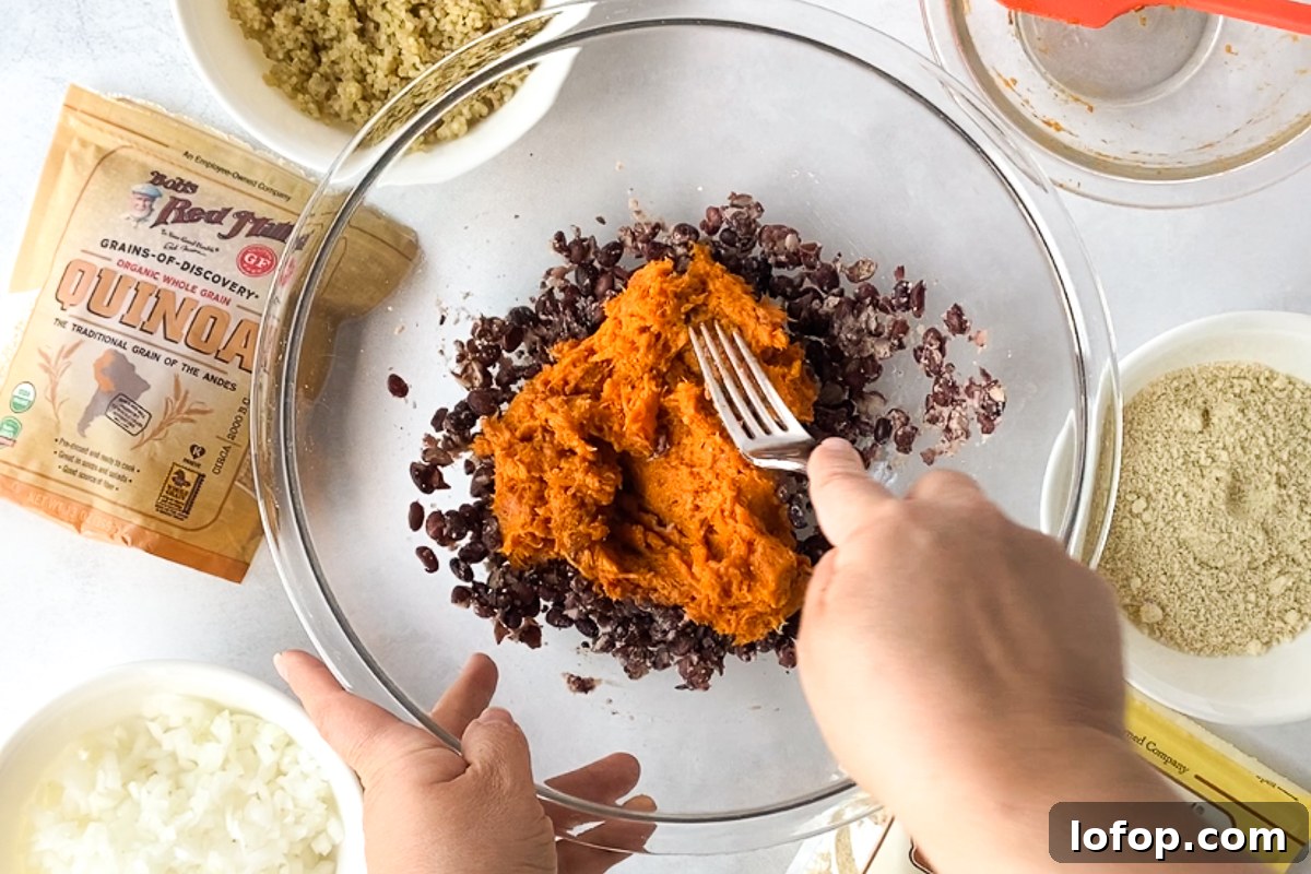 Sweet Potato and Black Bean Burger Recipe for Flavorful Veggie Meals 4 hand smashing sweet potato and black beans together in bowl