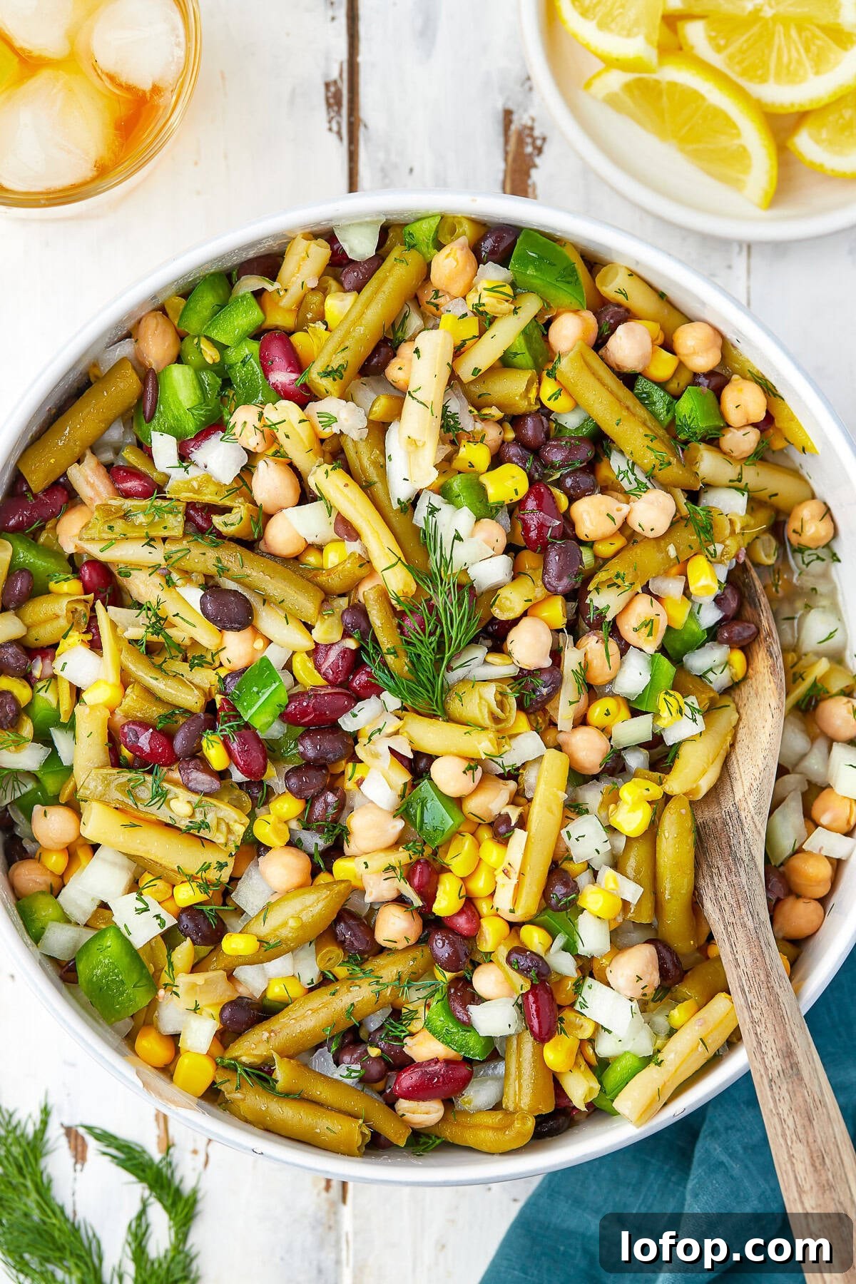 Creamy Vinaigrette Five-Bean Salad Recipe 2 A bowl of 5 bean salad with green beans, kidney beans, garbanzo beans, corn, and peppers in vinaigrette.