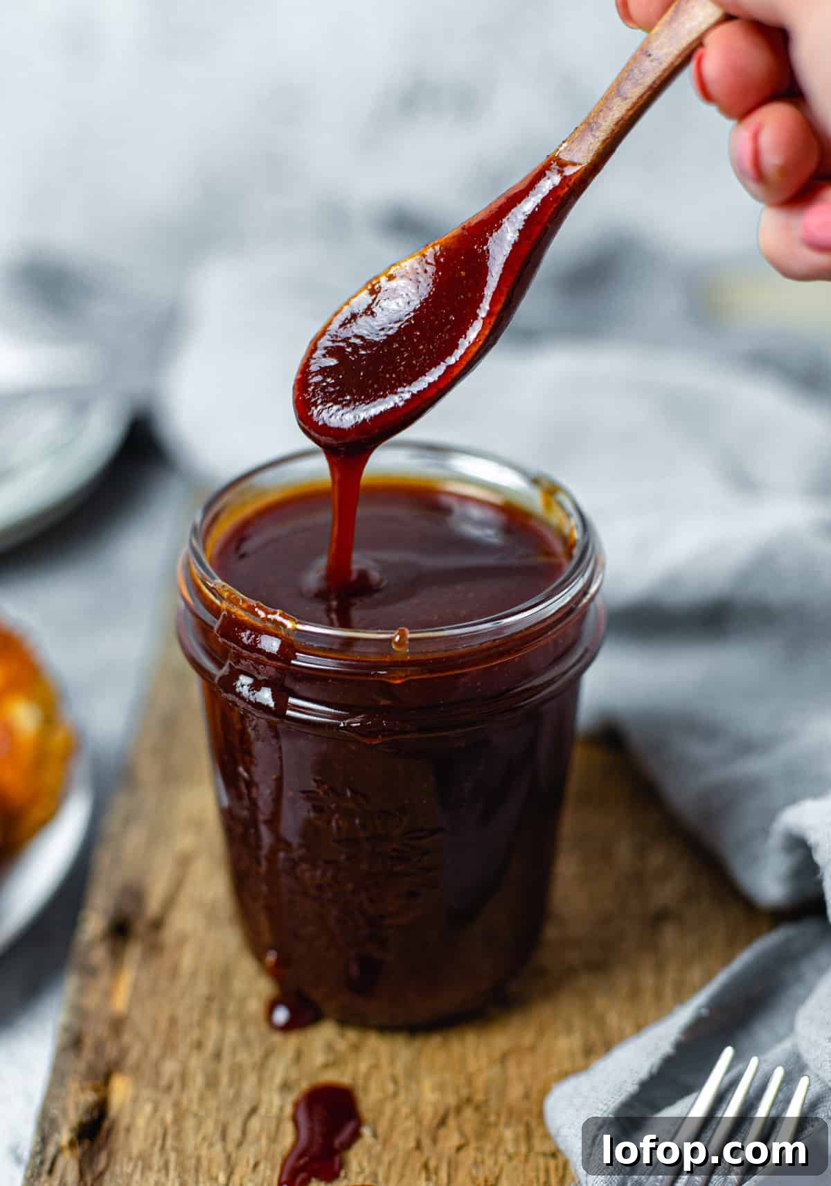 Spoon dripping Homemade BBQ Sauce Recipe in jar
