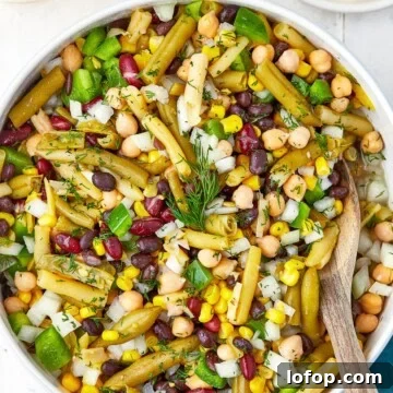 Creamy Vinaigrette Five-Bean Salad Recipe 13 A bowl of 5 bean salad with green beans, kidney beans, garbanzo beans, corn, and peppers in vinaigrette.
