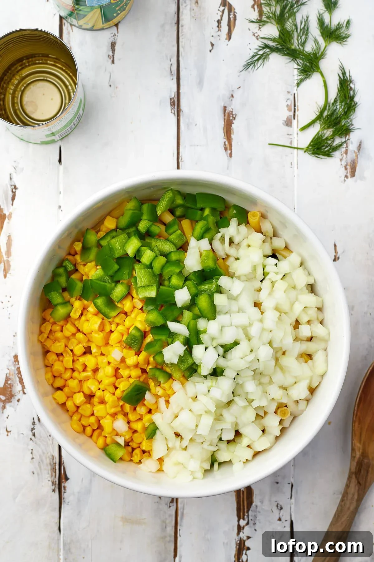 Creamy Vinaigrette Five-Bean Salad Recipe 4 Five kinds of beans, corn, bell pepper, and onion combined in a white bowl for bean salad.