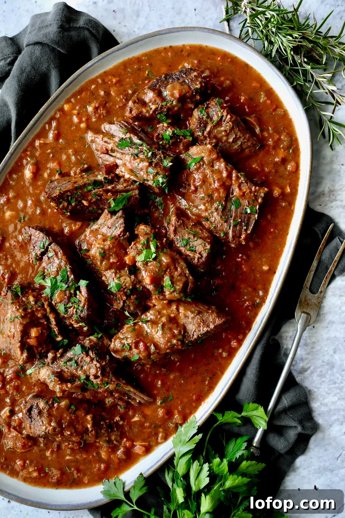 Authentic Stracotto: Italian Pot Roast Recipe for Slow-Cooked Beef 2 Italian Pot Roast (Stracotto) on gray-rimmed platter.